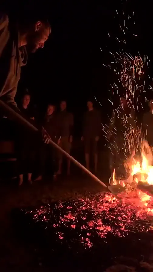 Ėjimo per žarijas ritualas: Ignas Bakėjus paruošia žarijų taką, aplink susirinkę dalyviai